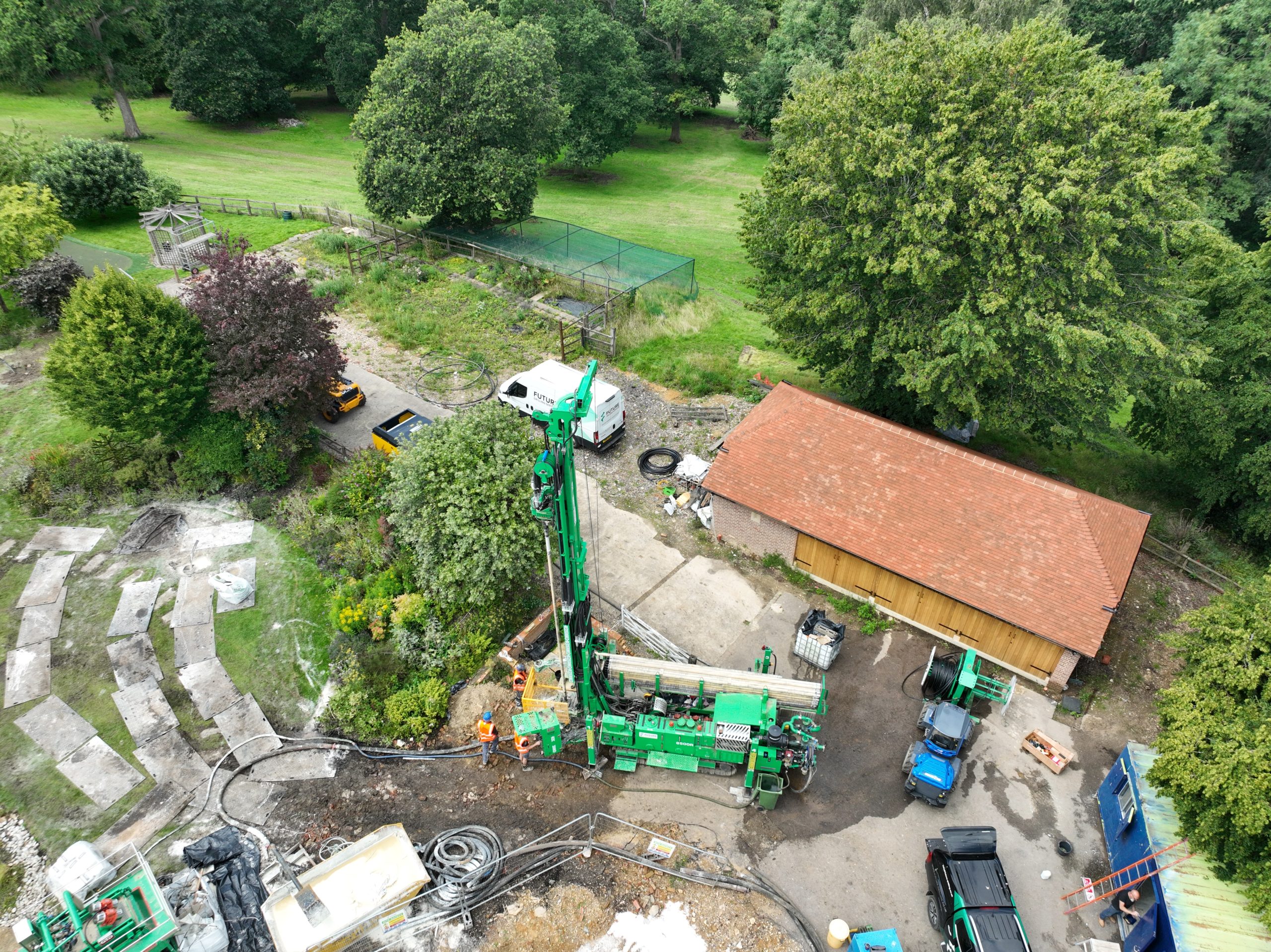 Aerial view of a geothermal drilling rig, ground loop coils and crew